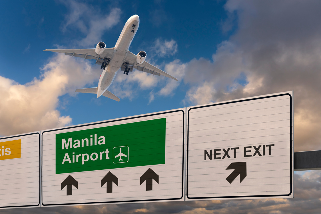 Road sign indicating the direction of Manila airport and a plane that just got up.